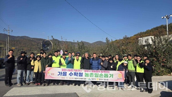 사과 수확 일손돕기 참여자들이 단체 촬영을 하고 있다. (사진제공=밀양시)